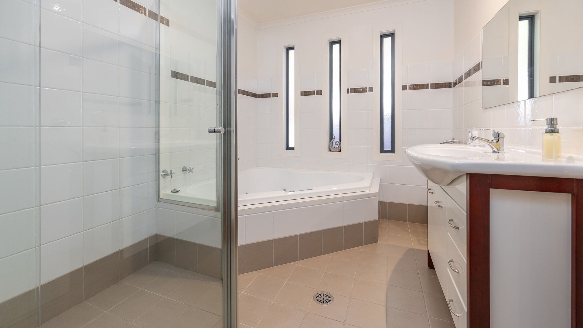 Un baño moderno con cabina de ducha de vidrio, una bañera independiente y un lavamanos.