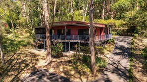 Een huis op palen, omgeven door bomen.