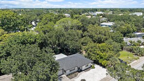 A residential area with houses surrounded by dense greenery. - Cozy Cottage Mins to Siesta Key & Downtown, Hot Tub (Sarasota)