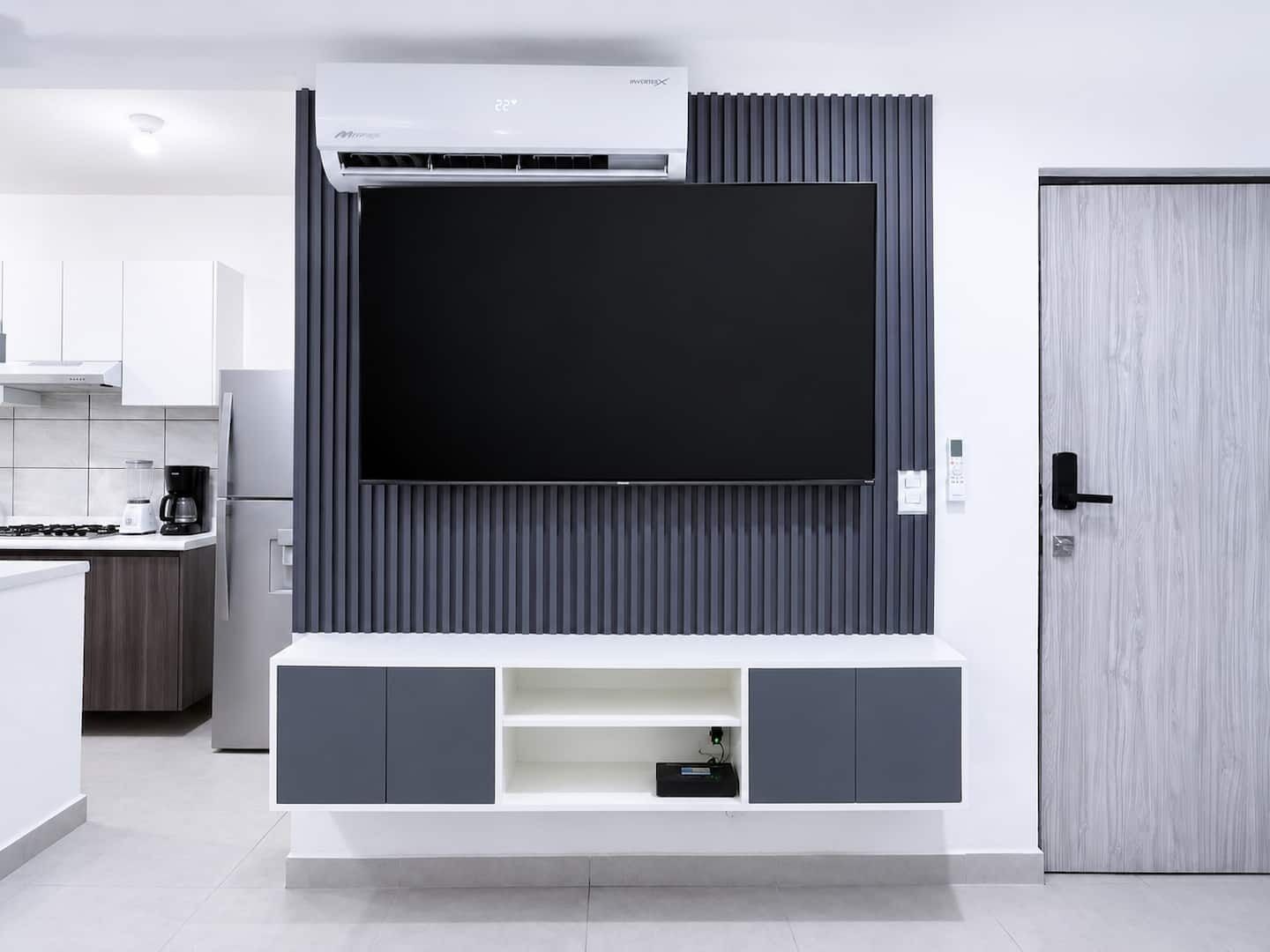 A modern kitchen with a built-in TV, a coffee maker, and a refrigerator.