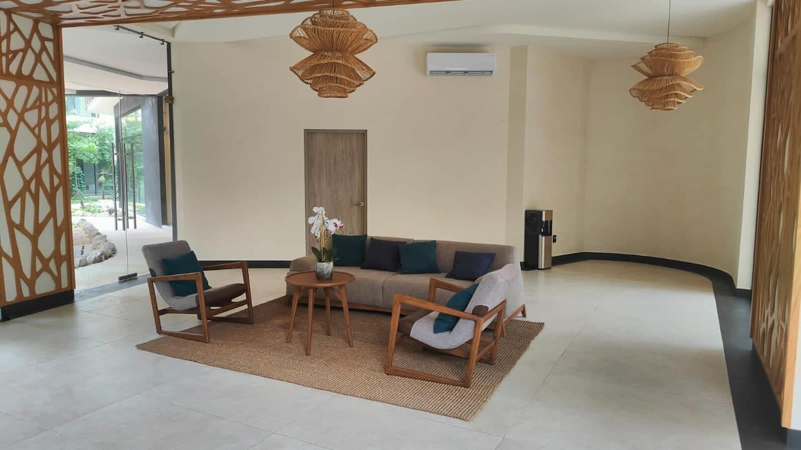 A modern living room with a sofa, two armchairs, a coffee table, and a decorative vase.