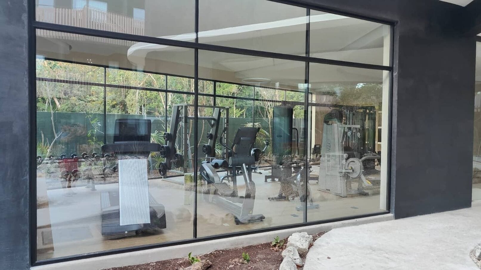 A gym with exercise equipment visible through large windows.