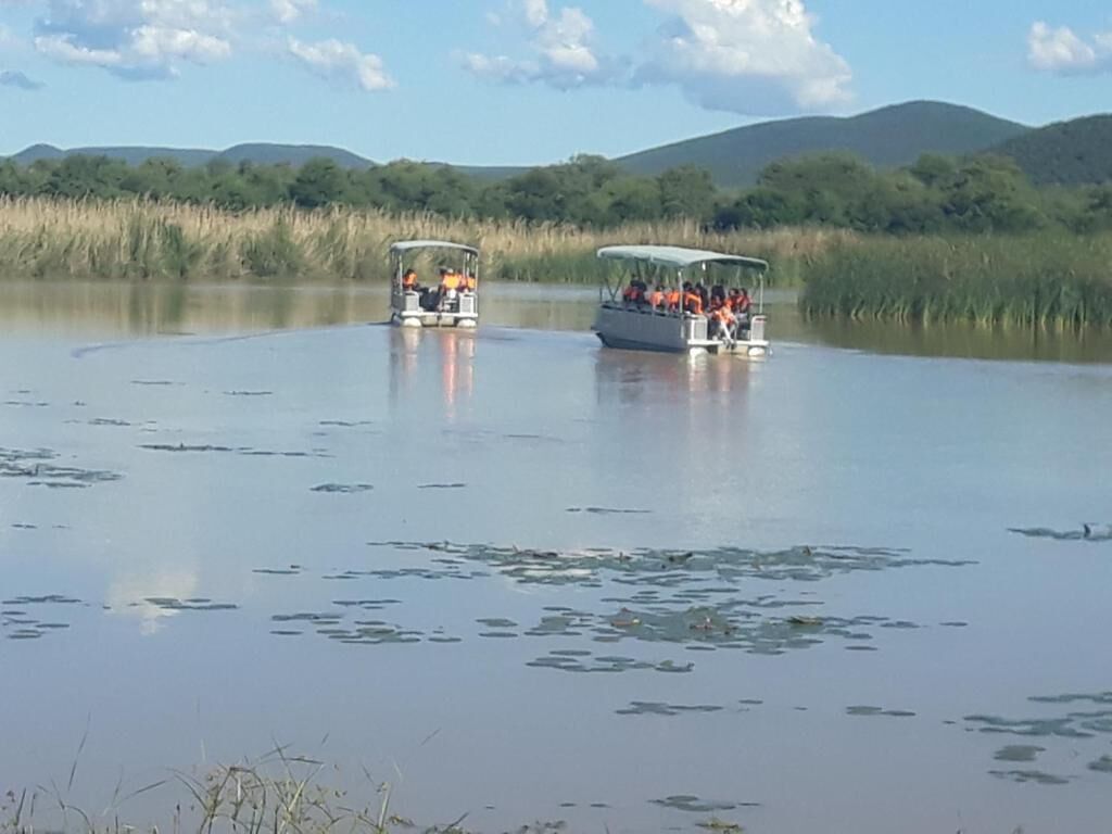Two boats on a calm lake with a forested landscape in the background.