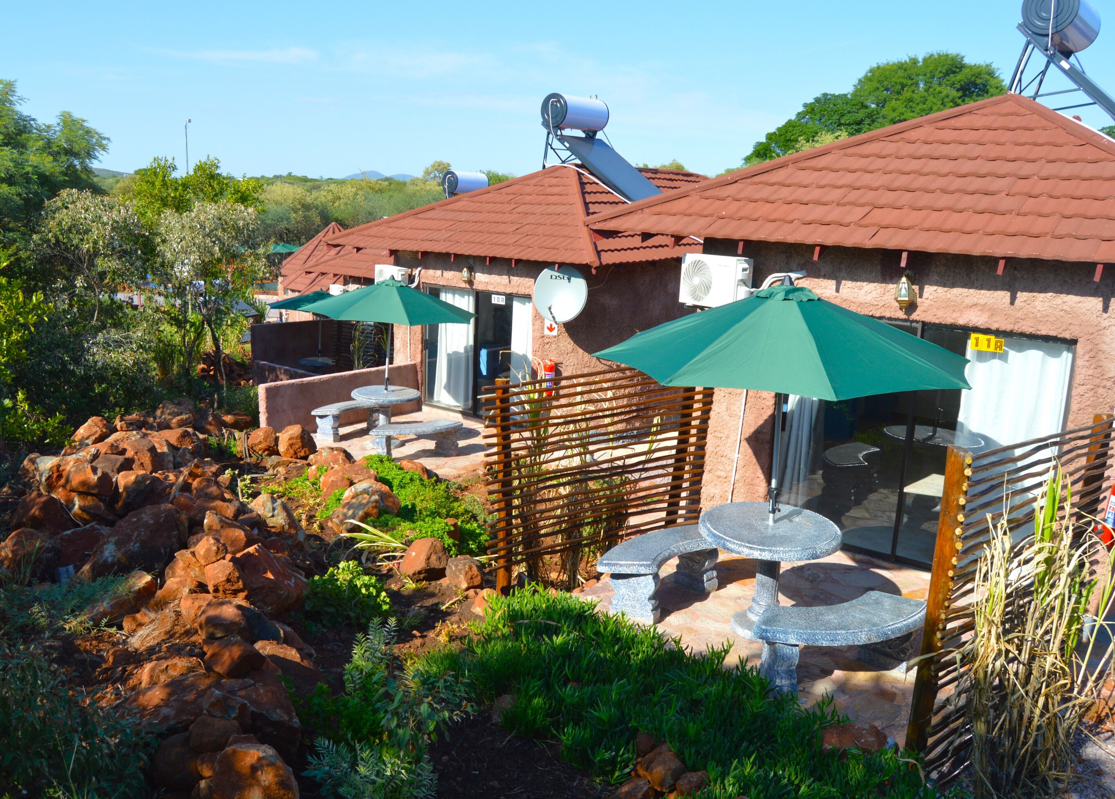 Un bâtiment doté d’une terrasse, d’une antenne parabolique et d’un mur en pierre.