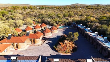 A resort with multiple round-roofed buildings, a swimming pool, and a rocky garden area.