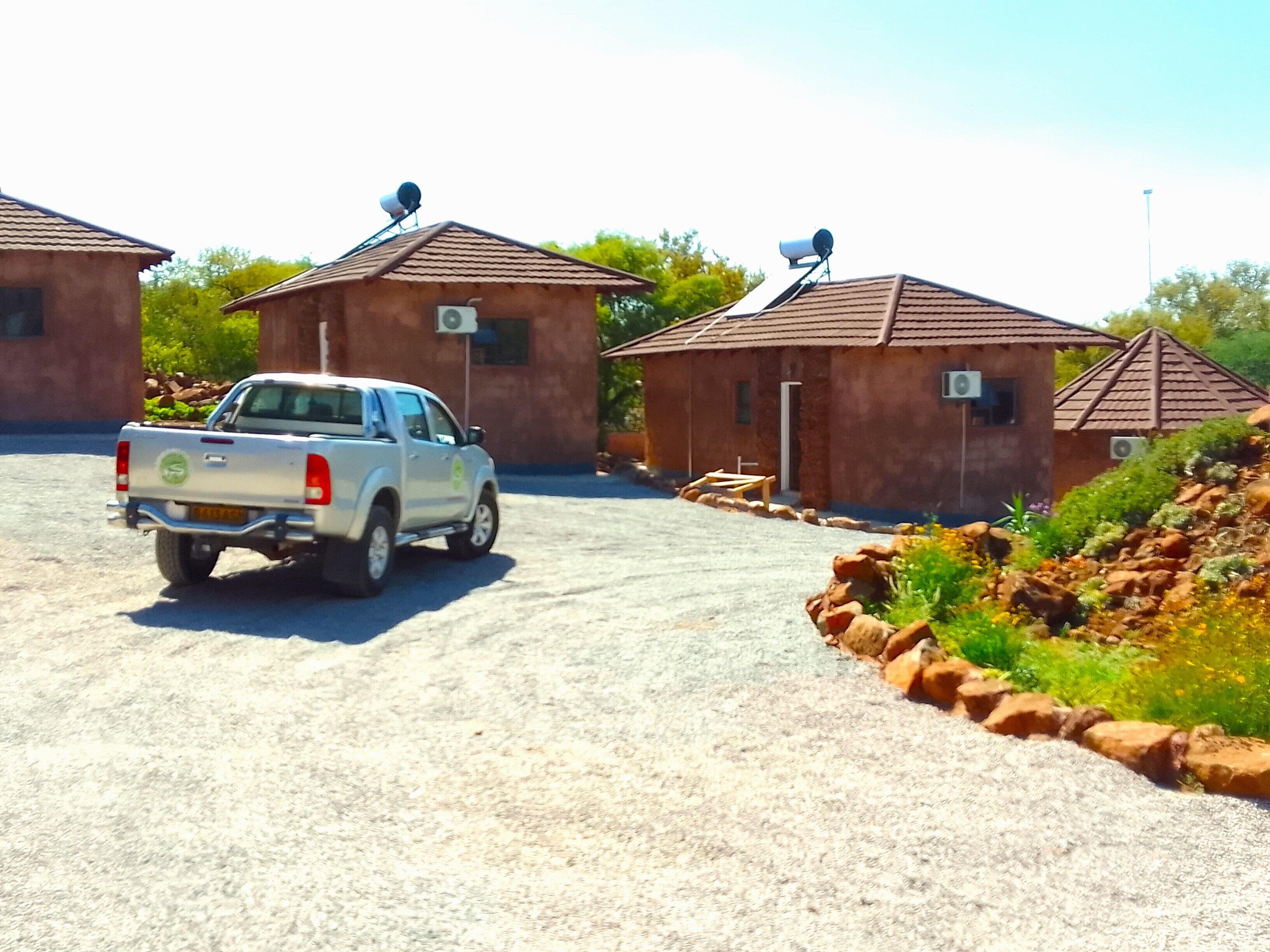 A gravel driveway leading to a building with satellite dishes.