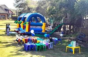 Un castillo inflable con toboganes y una mesa preparada para un evento.