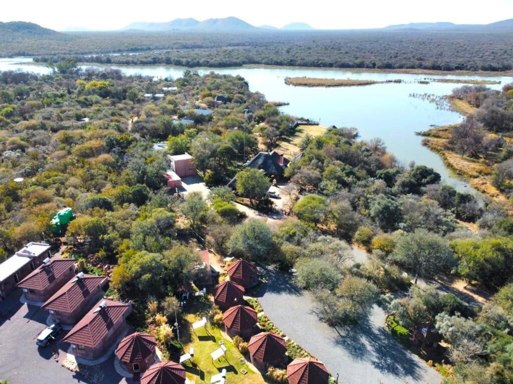 Una zona residencial con varias casas, una masa de agua y un paisaje montañoso al fondo.