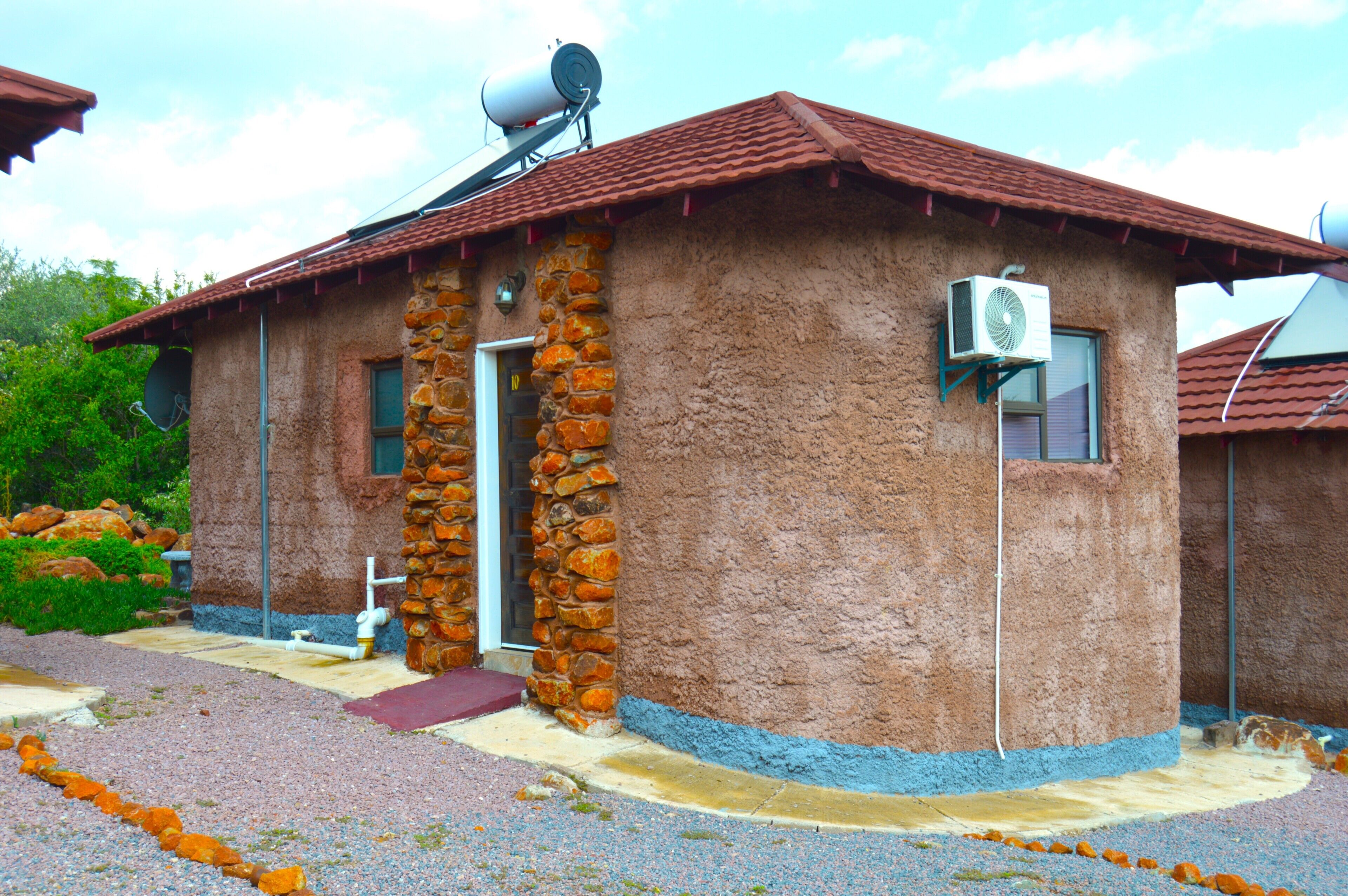 A rustic building with a stone facade, a satellite dish, and a small window.