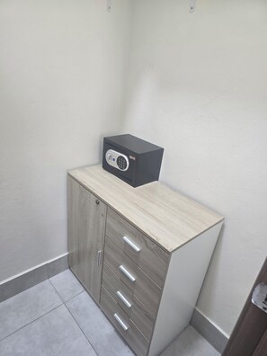 Ein Eckschrank mit Schubladen und einem schwarzen elektronischen Gerät darauf.