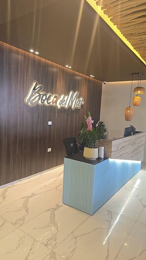 A reception desk with a wooden backdrop and a sign that reads 'Bordeaux'. - Relaxing condo walking distance to Beach and all your favorites things to do  . (Boca Chica)