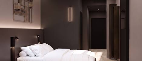 A modern bedroom with a bed, bedside tables, and a wall-mounted light fixture.