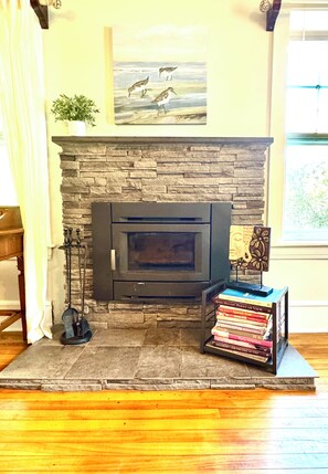 A stone fireplace with a mantel shelf, a small potted plant, and a framed picture above it. - Ancestral Charming Home - Central Downtown Charlottetown (Charlottetown)