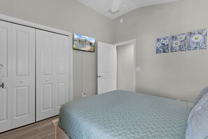A bedroom with a bed, a wardrobe, and a door.