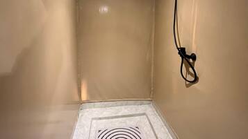 A room with beige walls, a white tiled floor, and a ceiling with recessed lighting.