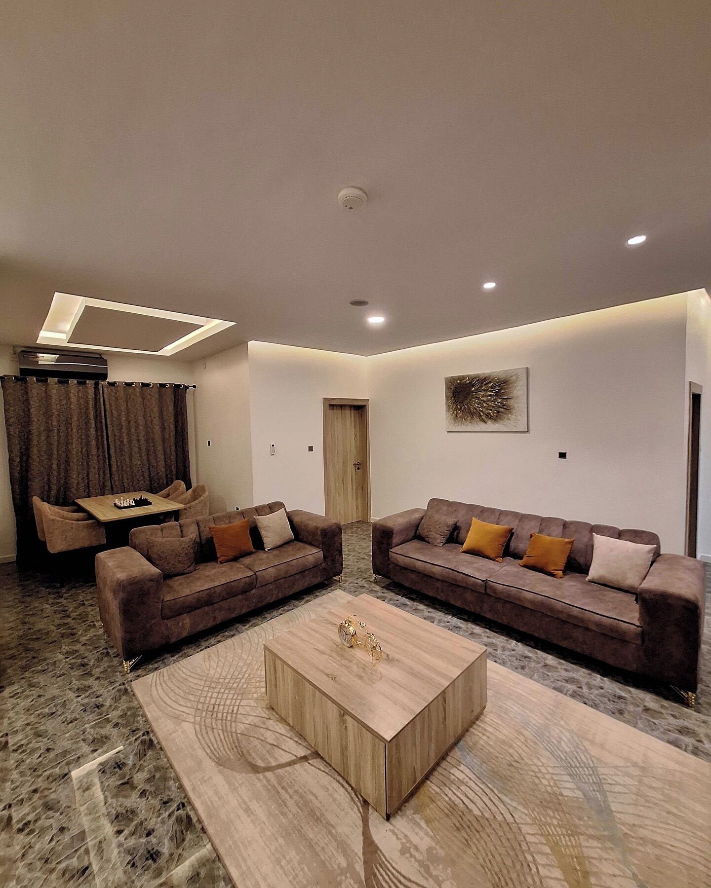 Un salon moderne comprenant deux canapés, une table basse et un coin repas avec une table et des chaises.