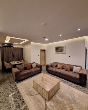A modern living room with two sofas, a coffee table, and a dining area with a table and chairs.