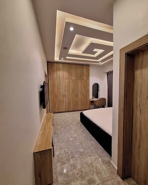 Un dormitorio moderno con cama, armario de madera y tocador con espejo.