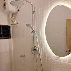 A bathroom with a shower, a toilet, and a mirror. - The Royals Apartment  (Ibadan)