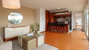 A modern living room with a glass coffee table, a round mirror, and a sofa. - w* | Deluxe 1BR w/ Terrace in Barranco (Lima)