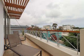 A balcony with a view of the city, a chair, and a potted plant. - w* | Deluxe 1BR w/ Terrace in Barranco (Lima)