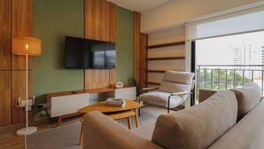 A modern living room with a flat-screen TV mounted on the wall, a sofa, a coffee table, and a chair. - w* | Welcoming 2BR w/ Balcony in Miraflores (Miraflores)