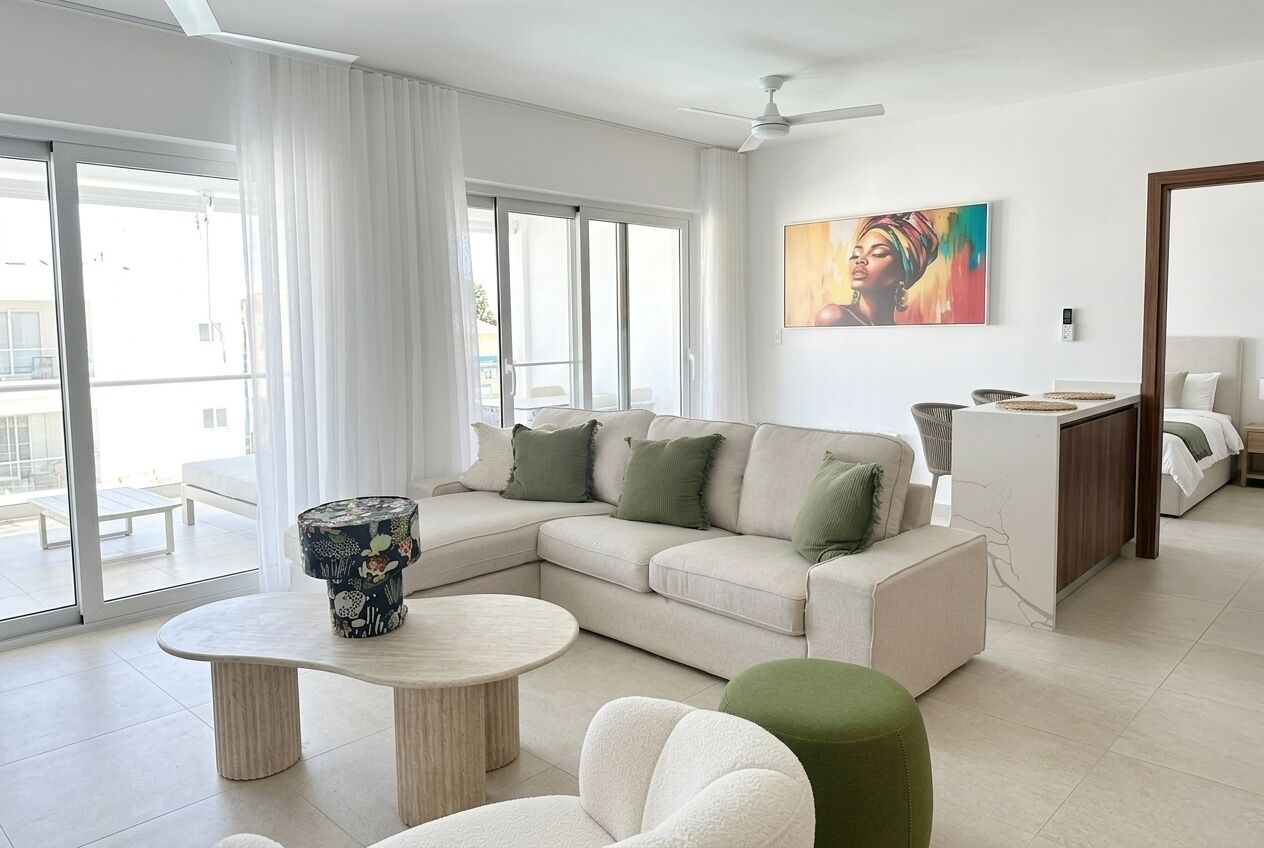 A modern living room with a sectional sofa, a round coffee table, and a large window with curtains.