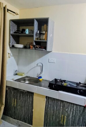 A kitchen with a sink, cabinets, and a stove. - Budget studio apartment in charming Rungiri Waiyaki way perfect for relaxing (Rungiri)