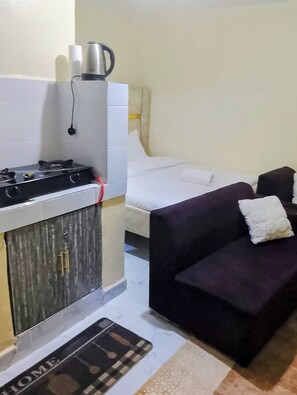 A compact living space with a kitchenette, a bed, and a sofa. - Budget studio apartment in charming Rungiri Waiyaki way perfect for relaxing (Rungiri)