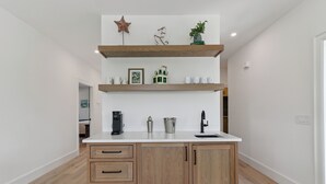 Eine Küche mit Holzausstattung, einer weißen Arbeitsplatte und einer Kaffeemaschine.