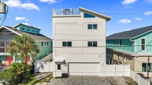 Um edifício residencial de vários andares com garagem, varanda e número de fachada visível.