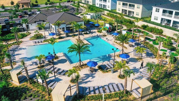 A resort with a central swimming pool, sun loungers, and palm trees. - Private Pool *Clubhouse Amenities *BBQ Grill (Kissimmee)