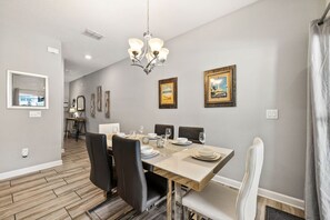 A dining area with a wooden table set for four, surrounded by black chairs. - Private Pool *Clubhouse Amenities *BBQ Grill (Kissimmee)