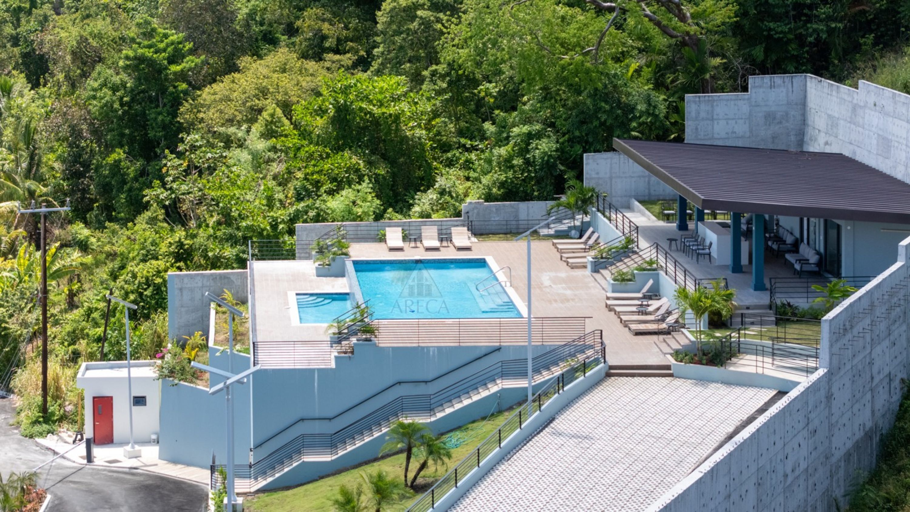 Un bâtiment moderne doté d’une piscine, d’un espace extérieur aménagé et offrant une vue sur la verdure environnante.
