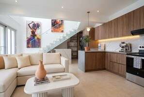 Een moderne keuken met een centraal eiland, houten inbouwkasten en een roestvrijstalen oven.