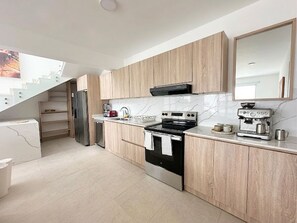 A modern kitchen with a built-in oven, a coffee machine, and a microwave. - Ocean View Penthouse with Private Rooftop (Cabarete)