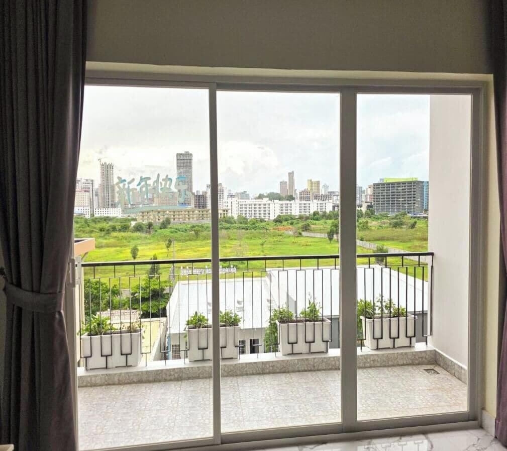 Ein Balkon mit Blick auf die Stadt, einem Geländer und Topfpflanzen.