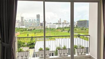 Ein Balkon mit Blick auf die Stadt, einem Geländer und Topfpflanzen.