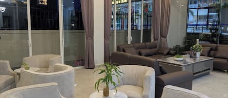 A modern interior with seating arrangements, a coffee table, and a potted plant.