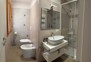 A modern bathroom with a toilet, bidet, and a glass-enclosed shower area. - Monet Suite, 100 meters from the Biennale - Canal View (Venezia)