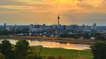 Eine Stadtansicht mit einem markanten Turm und einem Fluss im Vordergrund.