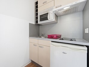 A compact kitchen with a microwave, a sink, and a dish rack. - Apartment with balcony and swimming pool (Grasse)