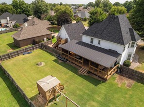 Una proprietà residenziale con una casa spaziosa, un cortile recintato e un patio in legno.