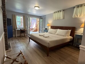 Un dormitorio con cama de madera, un escritorio y una silla.