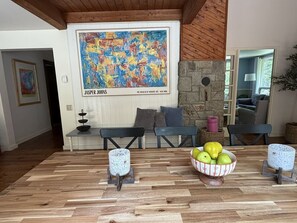 Un salón moderno con suelo de parqué, un cuadro grande de Jasper Johns y una chimenea de piedra.