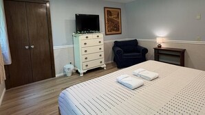 A bedroom with a bed, dresser, chair, and a television. - 5BR near Park & Downtown Bar Harbor! [North Lodge] (Bar Harbor)