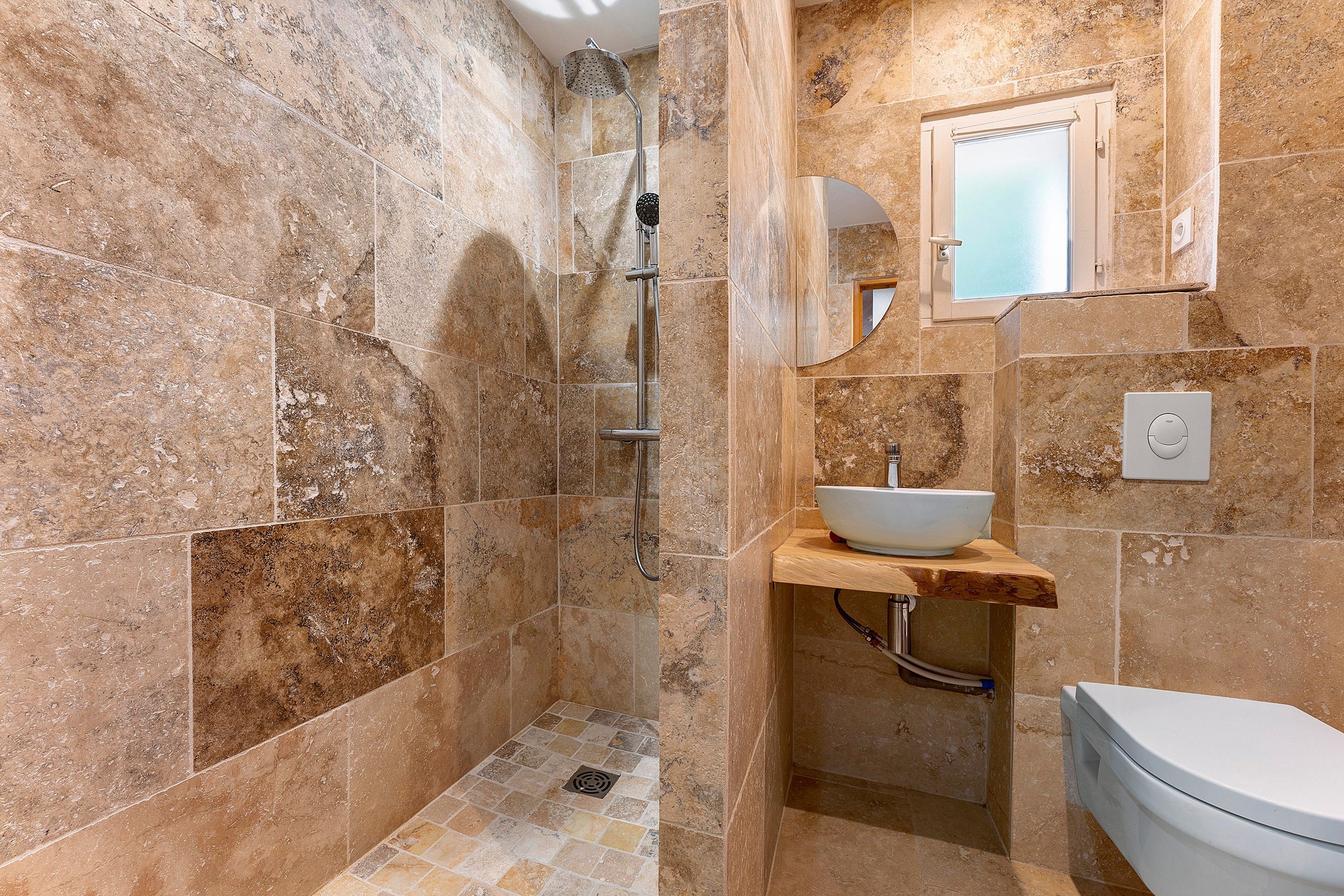 A bathroom with a shower, sink, and toilet.