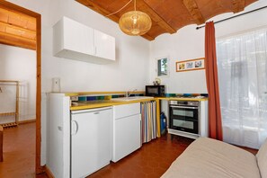 A compact kitchen with a refrigerator, microwave, stove, and a small sink. - Mas Pepette Gîte for 24 with Pool, Hot Tub, River Access (Vers-Pont-du-Gard)