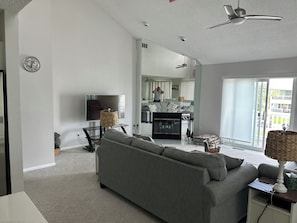 Ein modernes Wohnzimmer mit Sofa, Fernseher und Deckenventilator.