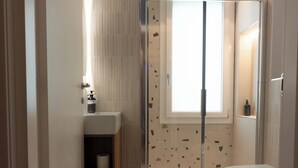 Un bagno moderno dotato di doccia, WC e lavandino.